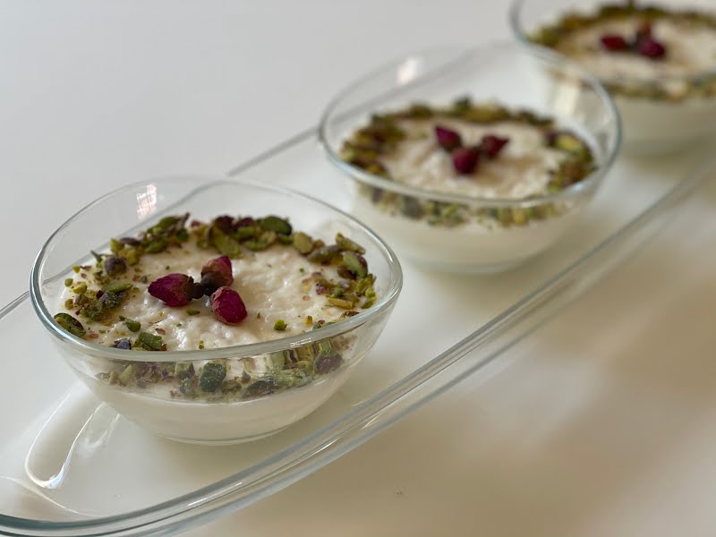 Mhallabiyyeh (a variation of Arabic milk pudding) decorated with pistachios and rose petals. Made with semolina seeds and rose water. ? Photo by Jktab, CC BY-SA 4.0, via Wikimedia Commons