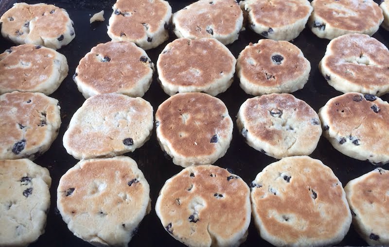 Welsh cakes cooking on a bake stone ? Photo by Vouliagmeni, CC BY-SA 4.0, via Wikimedia Commons