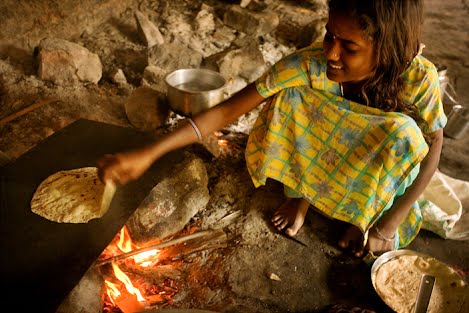A pilgrim girl in Mahakutta, India baking chapati bread in a temple. ? Photo by Claude Renault, CC BY 2.0, via Wikimedia Commons