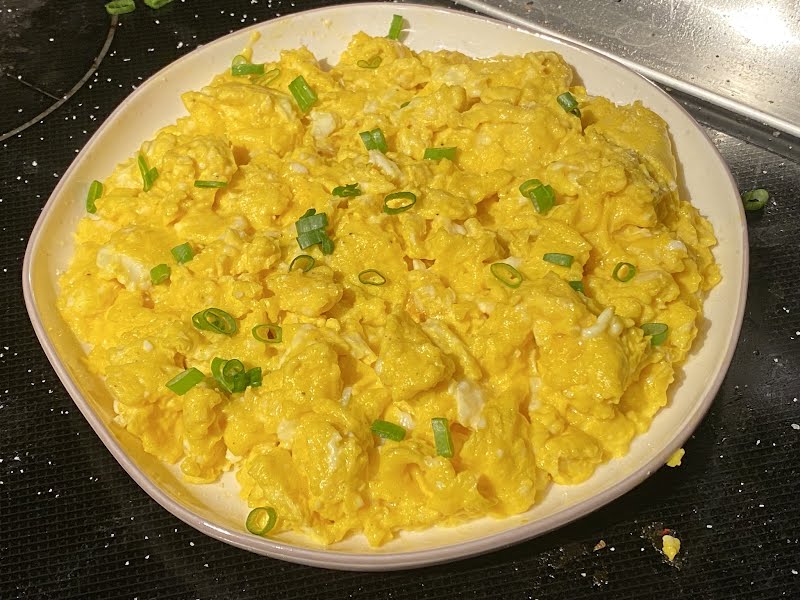 Freshly scrambled eggs, garnished with finely chopped onion