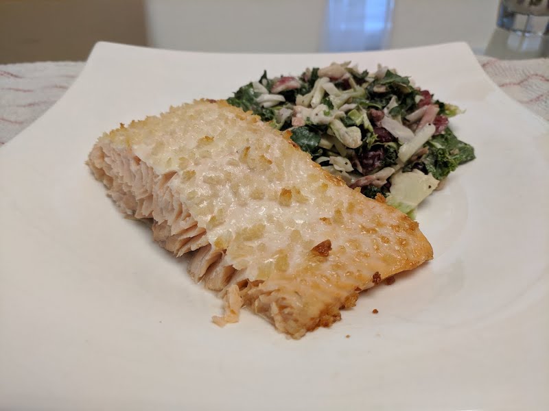a serving of baked salmon with some salad