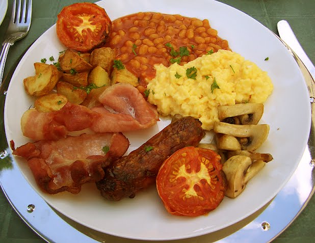 Freshly made English Breakfast with smoked back bakon, pork, sausage, scrambled eggs, fried potatoes, mushrooms, baked beans and fresh tomatoes. ? Photo by André Zahn, CC BY-SA 2.0 de, via Wikimedia Commons
