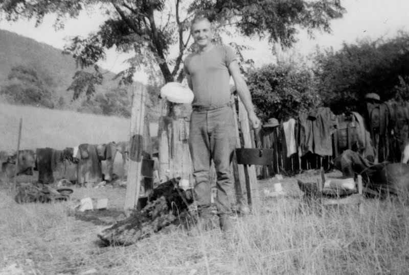 Freshly baked damper, with the camp oven that was used. Pack saddles and oilskin coats are drying on the fence, Oven Camp, Walcha, NSW. ? Photo by N.Goodwin, CC BY 3.0, via Wikimedia Commons