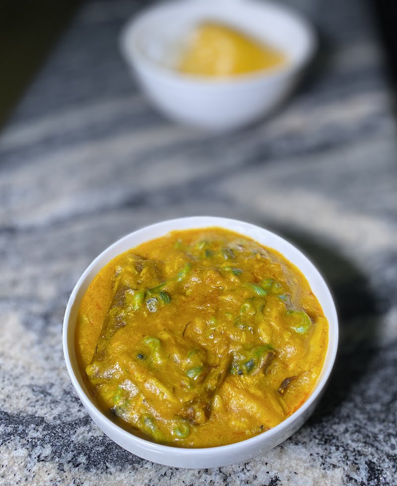 A picture of Oghwo soup. In the background of the picture is a wrap of Usi (Starch) ? Photo by Randybloc, CC BY-SA 4.0, via Wikimedia Commons