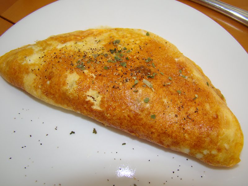 An omelet with ham, cheese, and a garnish of spices including oregano and parsley. ? Photo by Stripey the crab, CC BY-SA 3.0, via Wikimedia Commons